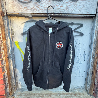 Black zip-up hoodie with barbed wire design on sleeves and a red outlaw patch on the chest.